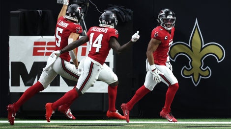 A group of five Chicago Bears players in blue jerseys celebrate a touchdown.