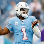 Titans QB Cam Ward, wearing a number 1 blue jersey, winds up to throw a football.