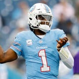 Titans QB Cam Ward, wearing a number 1 blue jersey, winds up to throw a football.