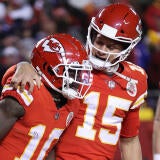 Patrick Mahomes puts his arm around Tyreek Hill and looks at him during a football game in 2022.