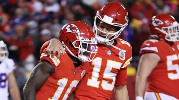 Patrick Mahomes puts his arm around Tyreek Hill and looks at him during a football game in 2022.